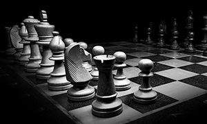 white pieces on chess board in shadow.,.